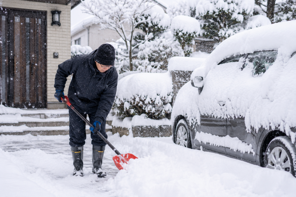 大雪の中で雪かきする男性